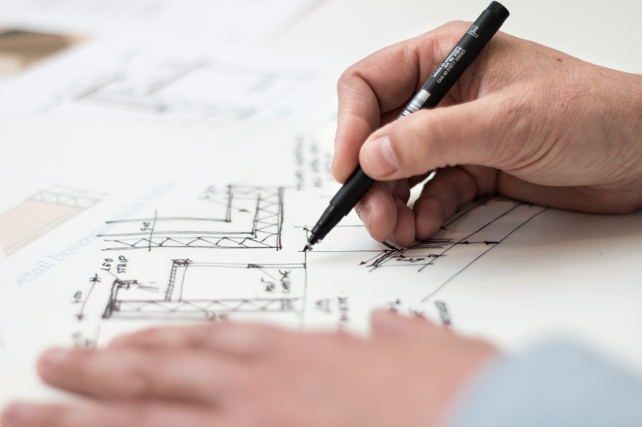 why-choose-us Close-up of hand drawing intricate technical designs on blueprint with pen, ideal for engineering or architecture themes.