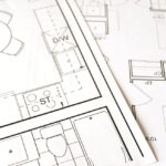 Close-up view of an architectural floor plan on paper showcasing detailed room layouts and measurements.